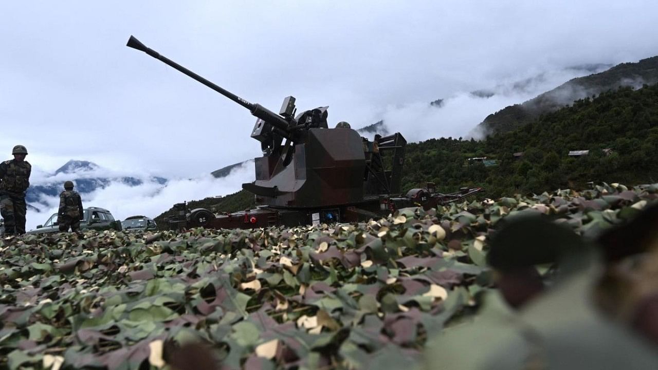 An Indian Army soldier sits inside an upgraded L70 anti aircraft gun in Tawang, near the Line of Actual Control (LAC) in Arunachal Pradesh. Credit: AFP Photo