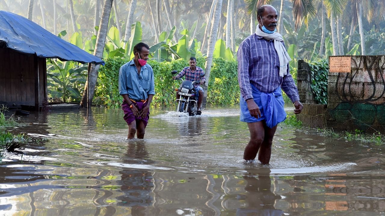 Commuters wade through a waterlogged street after heavy rain in Thiruvananthapuram. Credit: PTI File Photo