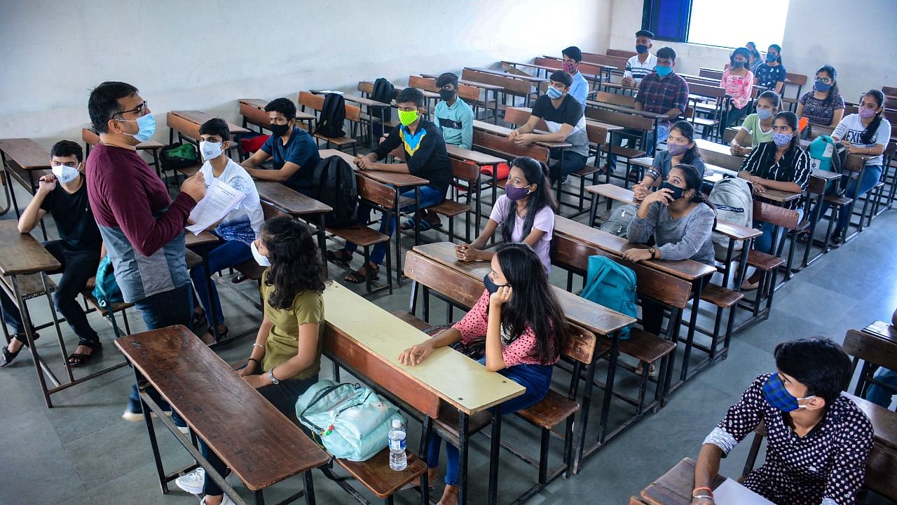 Students attend a class at a college after the Maharashtra government allowed colleges to reopen, in Thane. Credit: PTI Photo