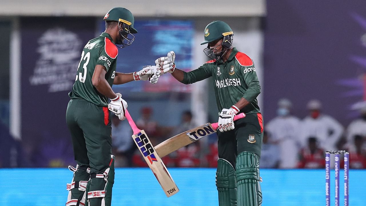 Bangladesh's Mahedi Hasan (R) bumps his fist with teammate Mohammad Naim during their match against Oman in the ICC T20 World Cup. Credit: AFP File Photo