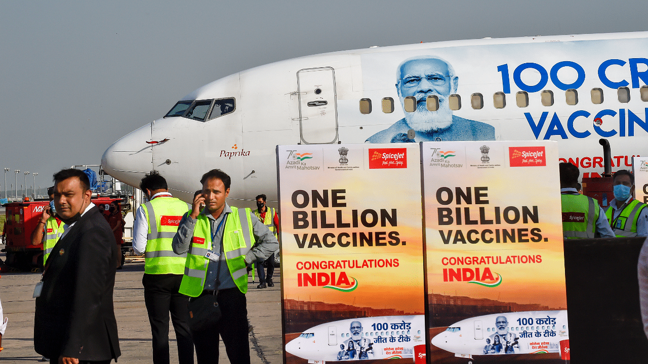 Posters announce about the 1 billion Covid-19 vaccination milestone crossed by India, during the unveiling of SpiceJet's special aircraft livery, at IGI airport in New Delhi. Credit: PTI Photo
