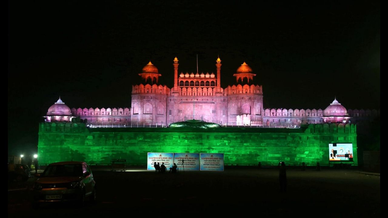 Red Fort illuminated with tri-colour lights as India crossed the 100 crore Covid-19 vaccination milestone, in New Delhi. Credit: PTI Photo