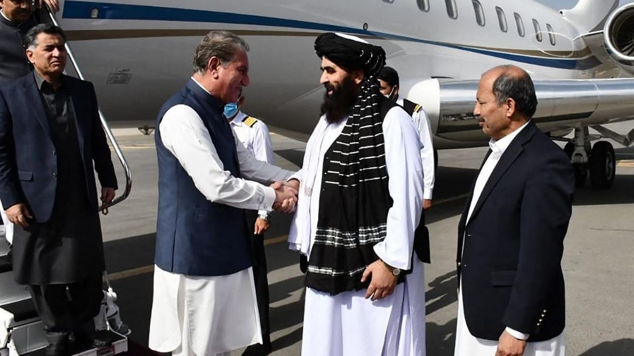 Afghanistan's acting Foreign Minister Amir Khan Muttaqi (2R) receives Pakistan's Foreign Minister Shah Mahmood Qureshi (3L) upon his arrival at the airport in Kabul. Credit: AFP Photo/Pakistan Foreign Office