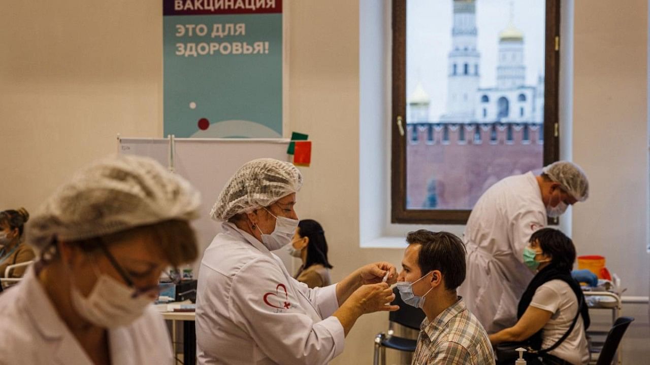 A healthcare worker administers a dose of Russia's Sputnik V Covid-19 vaccine to a patient at a vaccination centre in the GUM State Department store in Moscow. Credit: AFP File Photo