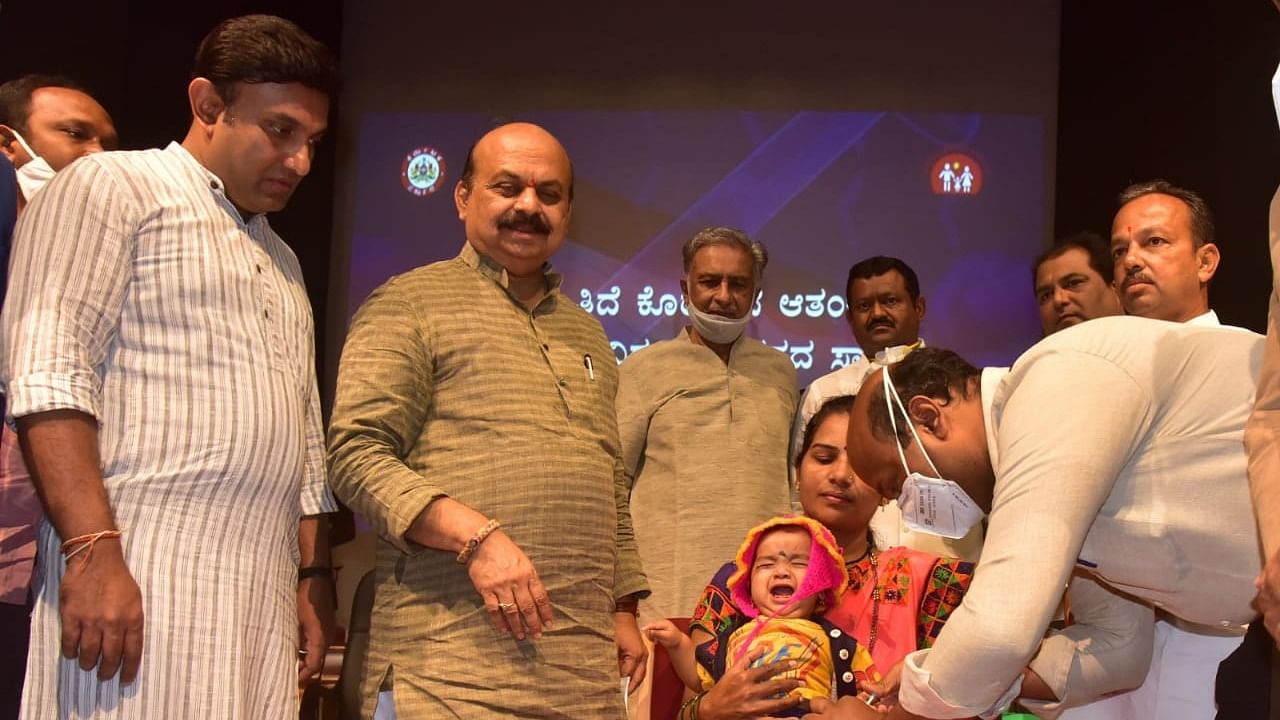 PCV being administered to a baby in the presence of Chief Minister Basavaraj Bommai at KIMS in Hubballi on Friday. Health Minister K Sudhakar, Legislative Council Chairman Basavaraj Horatti, Sugar Minister Shankar Patil Munenakoppa, and others are present. Credit: DH Photo