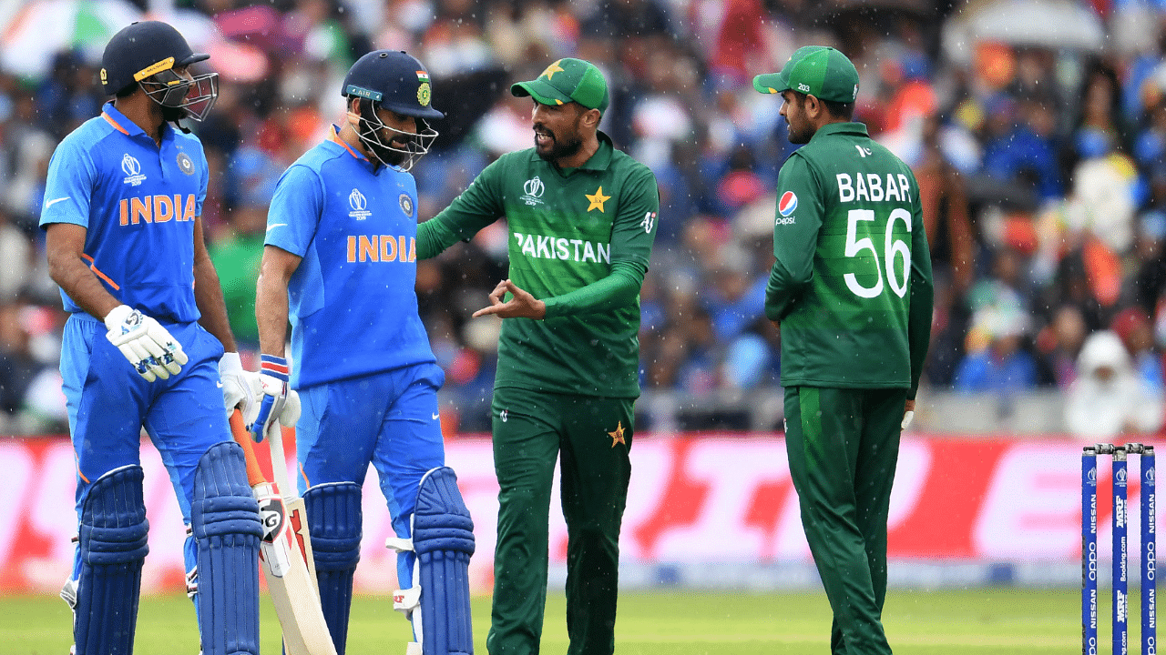 Pakistan's Mohammad Amir (2R) and teammate Babar Azam (R) speak with India's captain Virat Kohli (C) and India's Vijay Shankar. Credit: AFP Photo