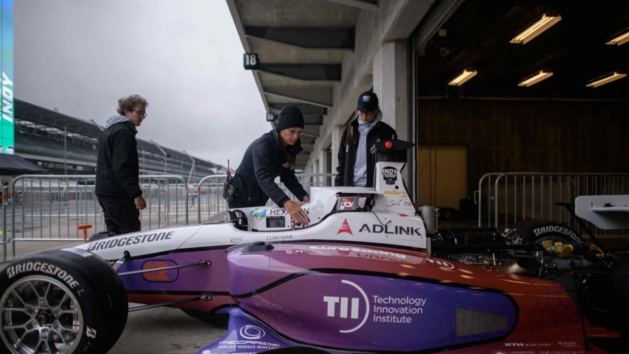 Members of the Euroracing team work on their car during preparations for the Indy Autonomous Challenge race at the Indianapolis Speedway. Credit: AFP Photo