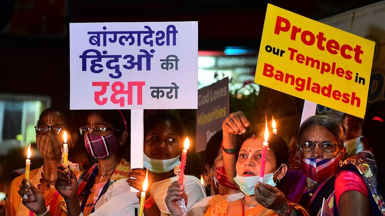 Demonstrators take out a candle light procession hold placards and chant religious prayers during a protest organised by International Society for Krishna Consciousness (ISKCON) in Allahabad on October 23, 2021, against the recent religious violence against the Hindu community in Bangladesh. Credit: AFP Photo