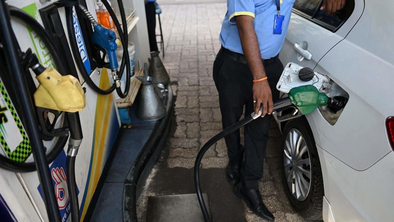 A worker fills up the tank of a car with diesel at a petrol station in New Delhi following a price hike of fuel and diesel. Credit: AFP Photo