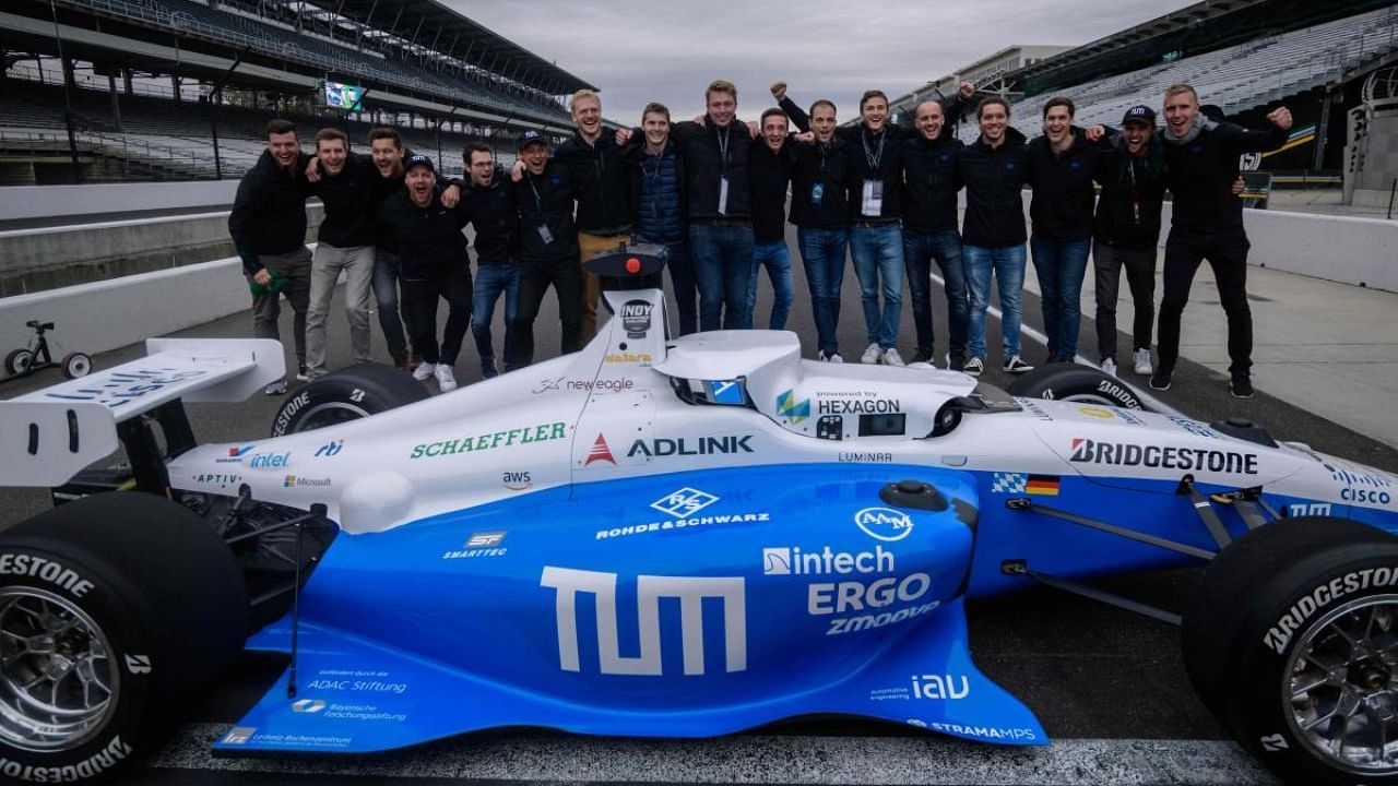 Team members of TUM Autonomous Motorsport pose for photos after winning the Indy Autonomous Challenge race at the Indianapolis Speedway in Indianapolis. Credit: AFP Photo