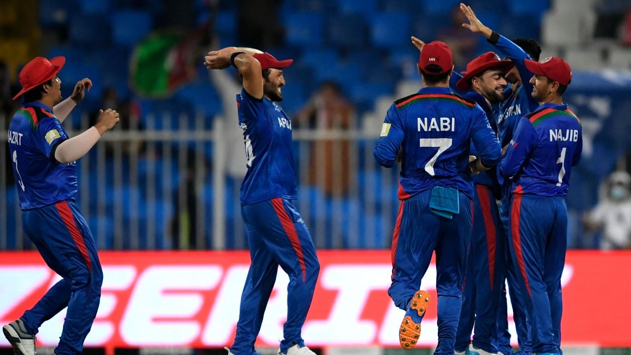 Afghanistan's players celebrate the dismissal of Scotland's Richie Berrington (not pictured) during the ICC men’s Twenty20 World Cup cricket match between Afghanistan and Scotland at the Sharjah Cricket Stadium in Sharjah on October 25, 2021. Credit: AFP Photo