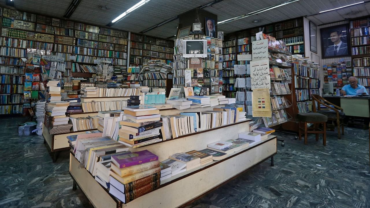 An employee works at the Al-Nouri bookstore, which was founded in 1930 and is threatened with closure, in Damascus. Credit: AFP Photo