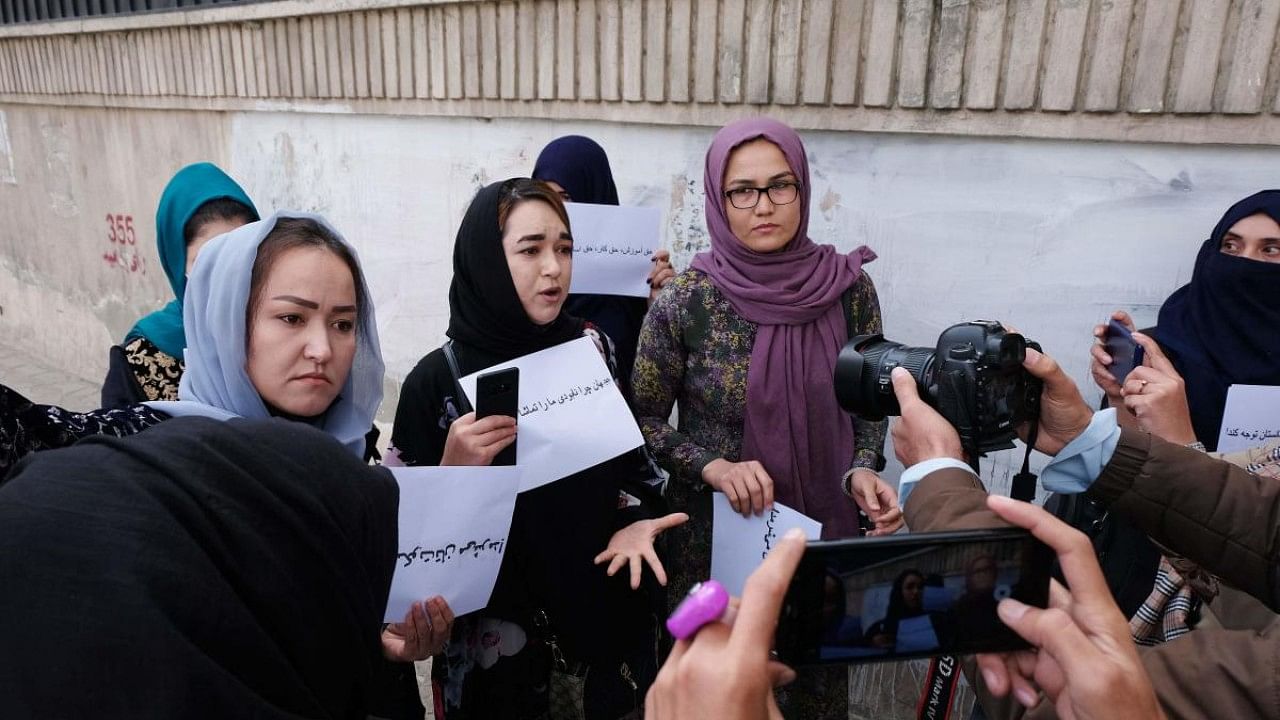 Women hold placards during a protest in Kabul calling for the international community to speak out in support of Afghans living under Taliban rule. Credit: AFP Photo