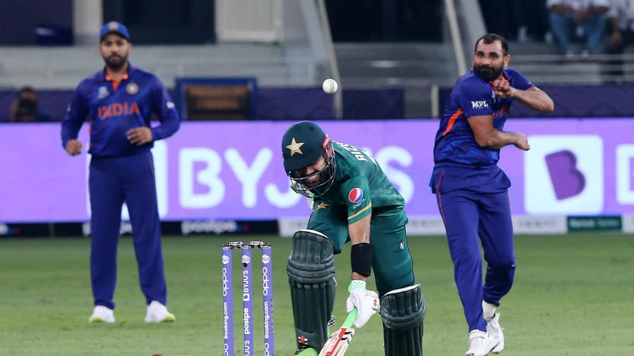 Pakistan's Mohammad Rizwan runs to his wicket as India's Mohammed Shami attempts to run him out. Credit: Reuters Photo