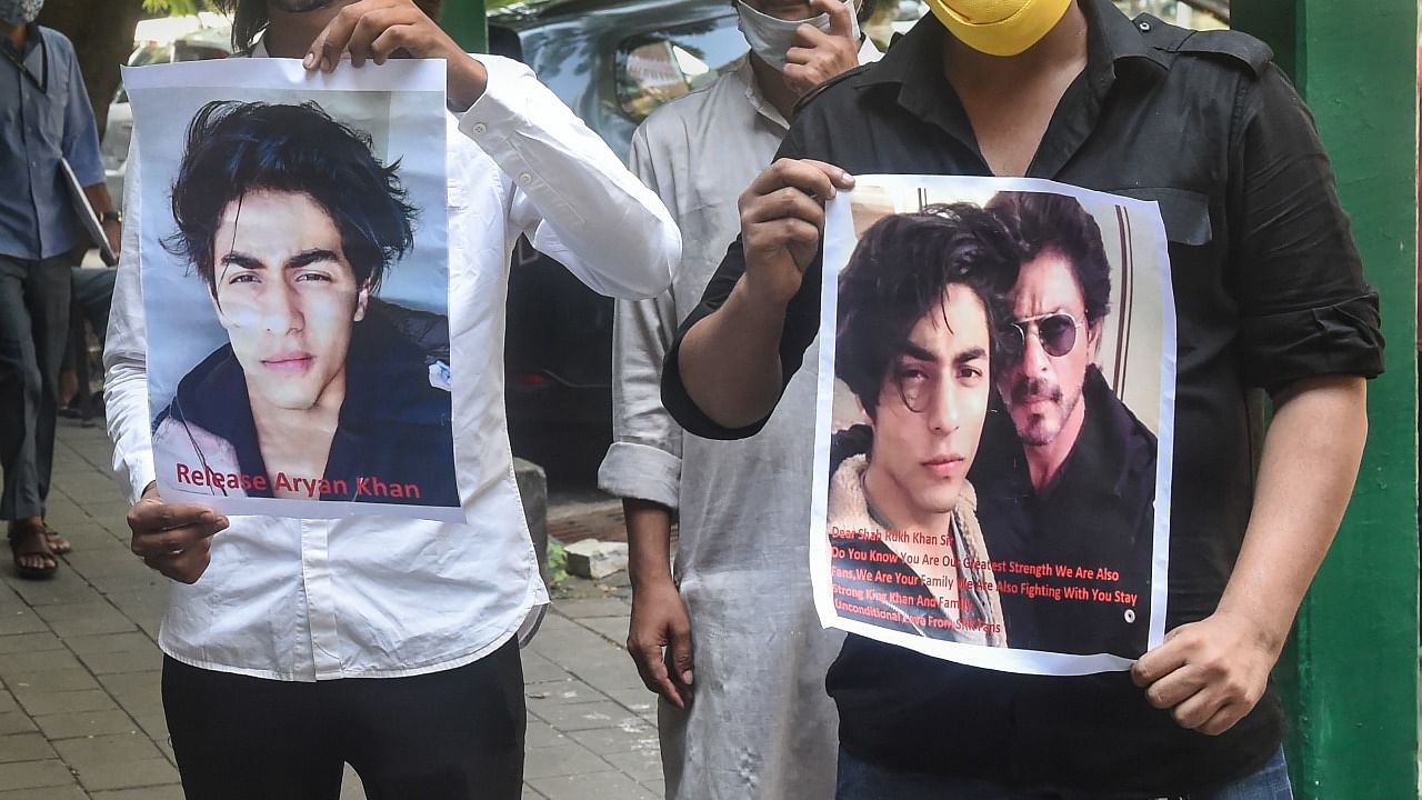 Fan's of Bollywood actor Shah Rukh Khan, hold posters written with 'Release Aryan Khan' stand outside Bombay High court in Mumbai, Tuesday. Credit: PTI Photo