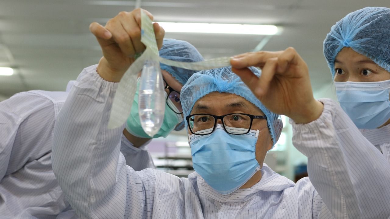 Founder and inventor of Wondaleaf Unisex Condom John Tang Ing Ching inspects the unisex condom at his factory in Sibu. Credit: Reuters Photo