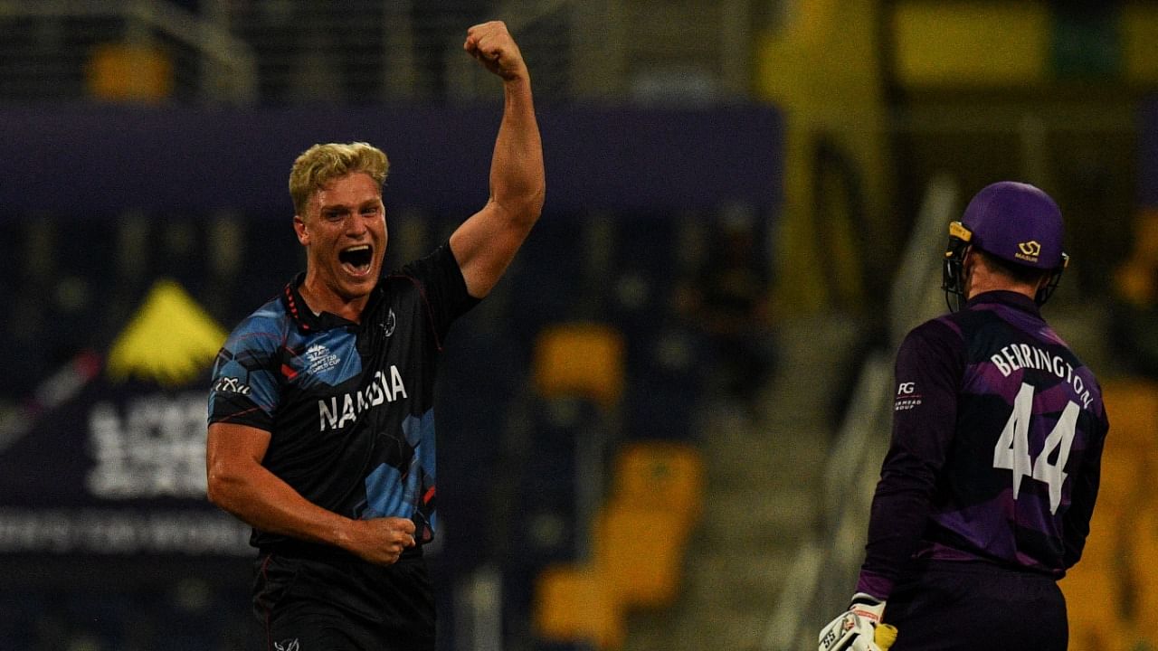 Namibia's Ruben Trumpelmann celebrates after the dismissal of Scotland's Richie Berrington (R) during the ICC men’s Twenty20 World Cup cricket match between Scotland and Namibia at the Sheikh Zayed Cricket Stadium in Abu Dhabi on October 27, 2021. Credit: AFP Photo