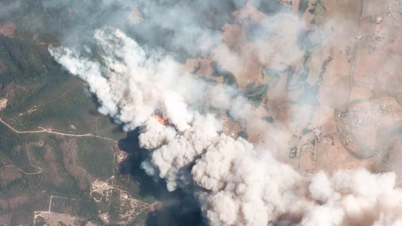 A satellite image shows smoke rising into the air from bushfires near Lake Conjolia in the Australian state of New South Wales. Credit: AFP Photo
