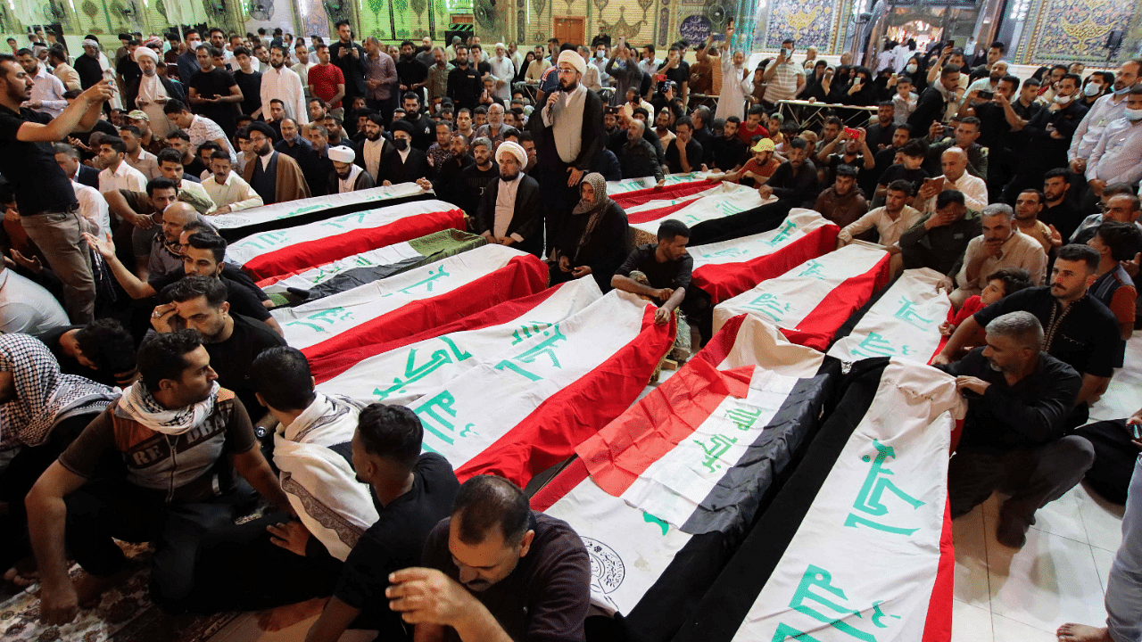 Mourners on October 27, 2021, surround the caskets of victims of yesterday's attack on the village of Al-Rashad in Iraq's eastern Diyala province that reportedly killed at least 11 people, during their funeral in the central shrine city of Najaf. Credit: AFP Photo