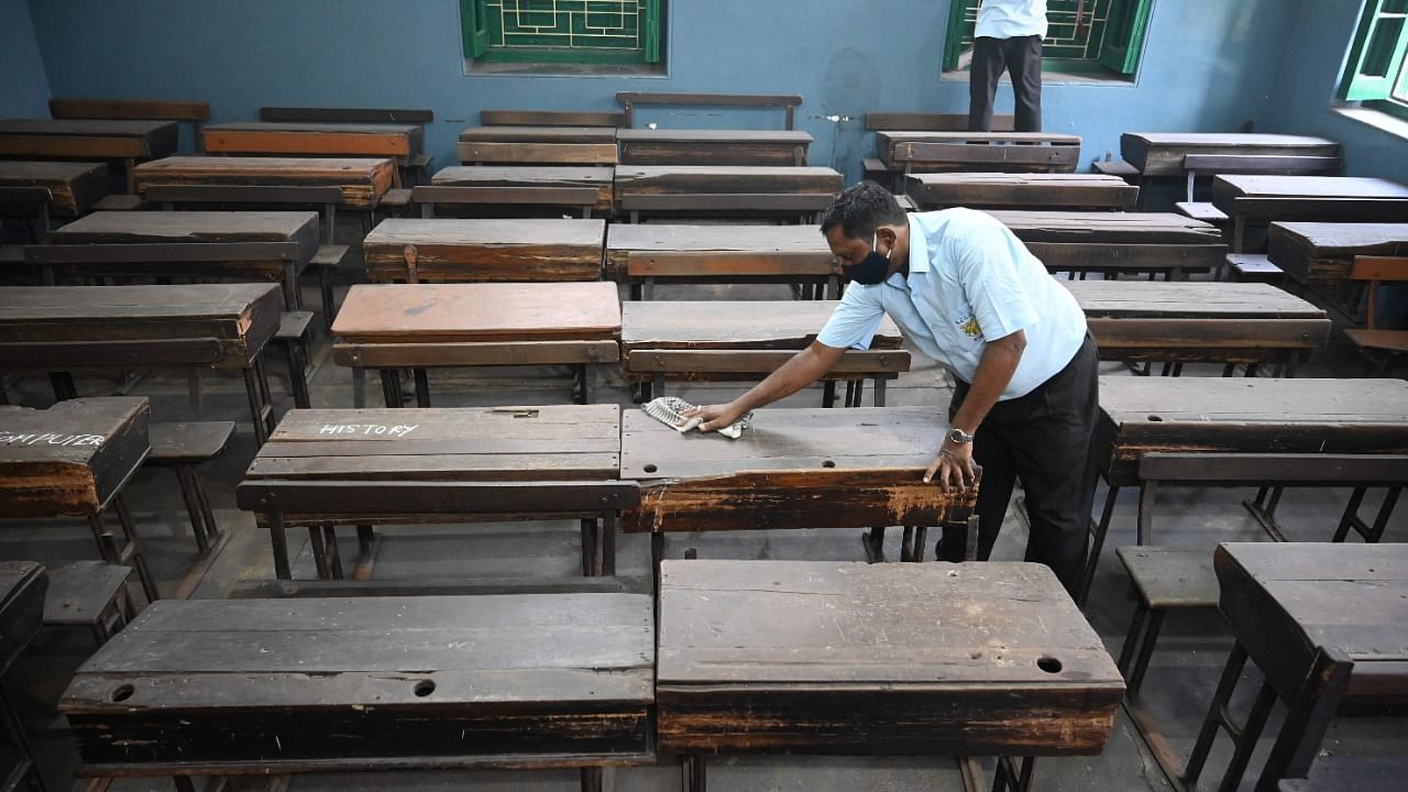 An employee of a government school cleans a classroom as West Bengal has announced the opening of all educational institutions across the state from November 16. Credit: AFP File Photo