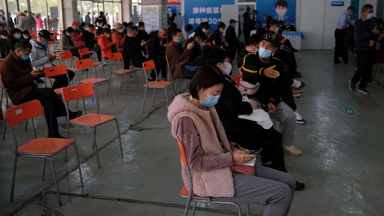 People wait at an observation area after receiving booster shots of Covid-19 vaccine at a vaccination site in Beijing. Credit: Reuters Photo