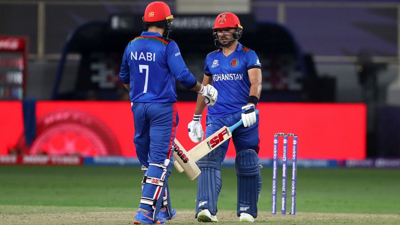 Afghanistan's Gulbadin Naib, right, and captain Mohammad Nabi celebrate scoring runs. Credit: AP Photo