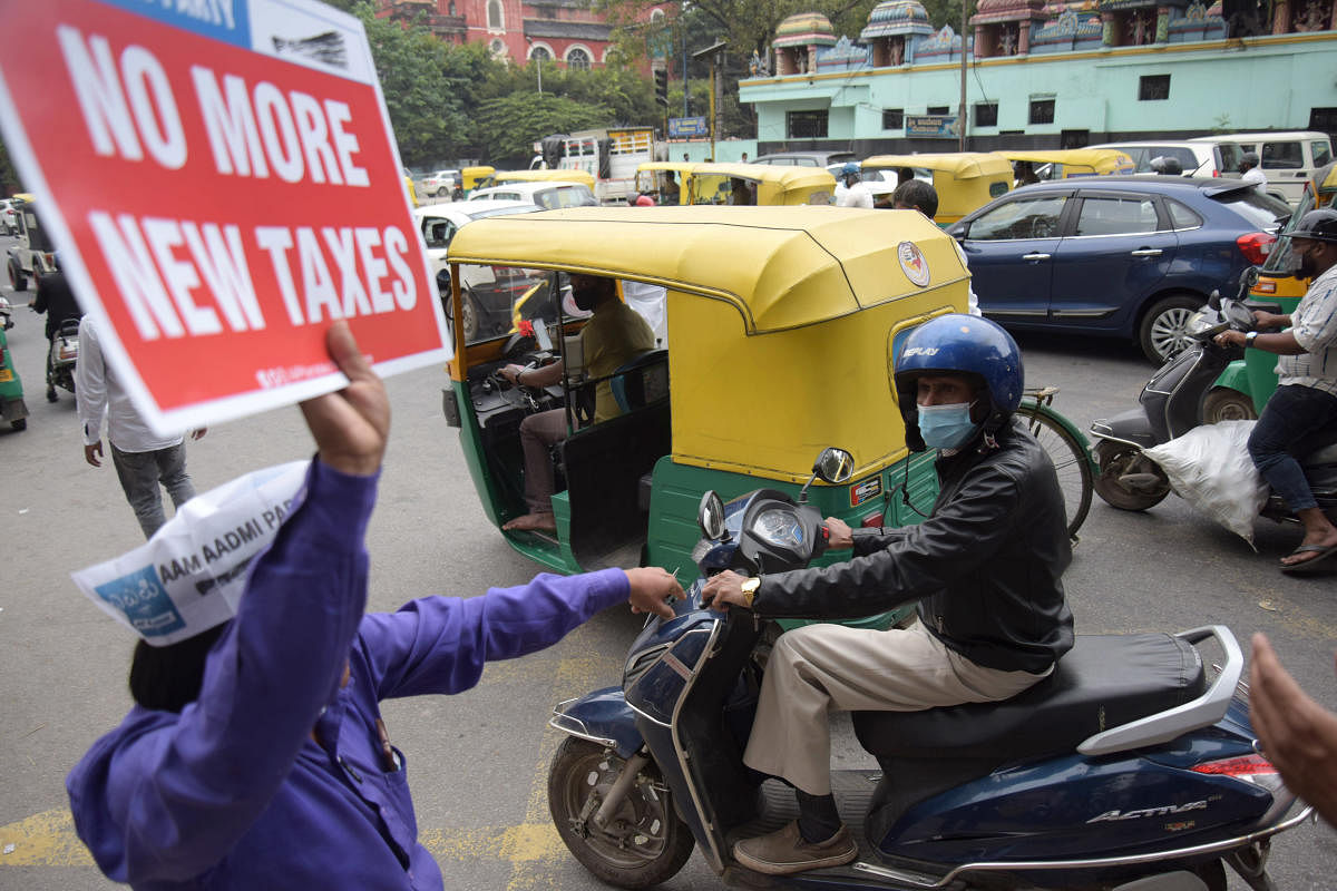 An AAP volunteer holds a placard during the protest against Parking Policy 2.0 at Mysore Bank Circle in Bengaluru on Friday, October 29, 2021. Credit: DH PHOTO/PUSHKAR V