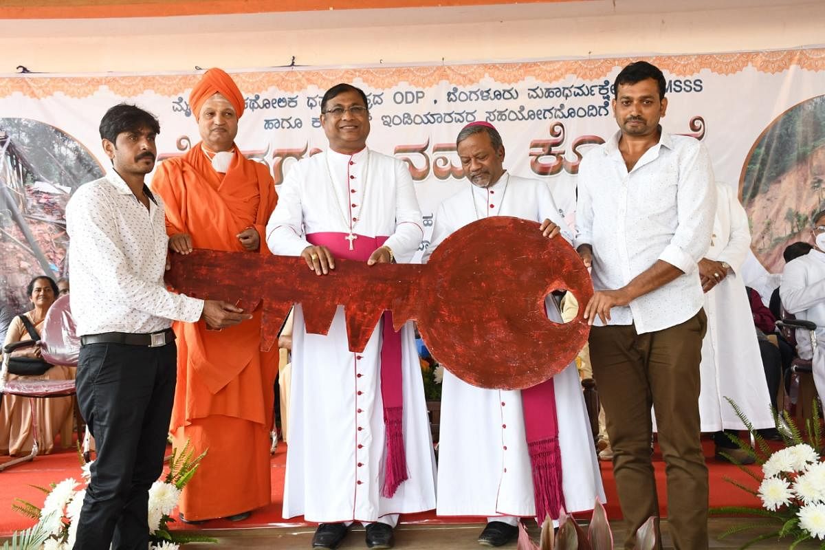 Dignitaries hand over the key to a house for a flood victim in Hattihole.