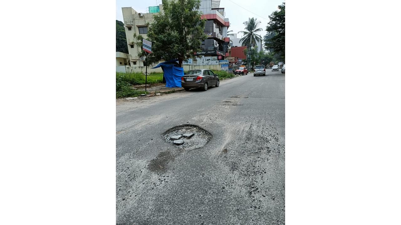 Rajajinagar resident Apoorva was riding to work when she ran into a pothole while trying to overtake an auto-rickshaw at 12th Cross in Ramco BHEL Layout. Credit: DH Photo