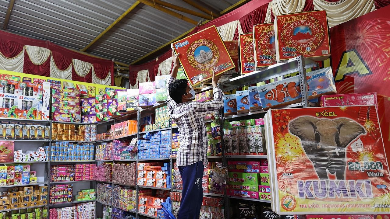 A shopkeeper arranges crackers at a shop for sale ahead of the Diwali festival. Credit: PTI Photo