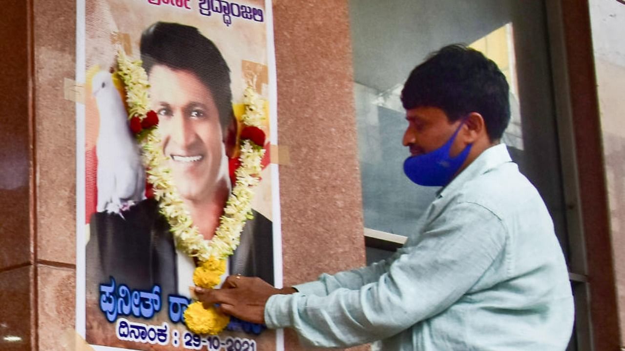 A fan pays tribute to Kannada superstar Puneeth Rajkumar, who passed away due to a fatal cardiac arrest, at his establishment in Bengaluru. Credit: PTI photo