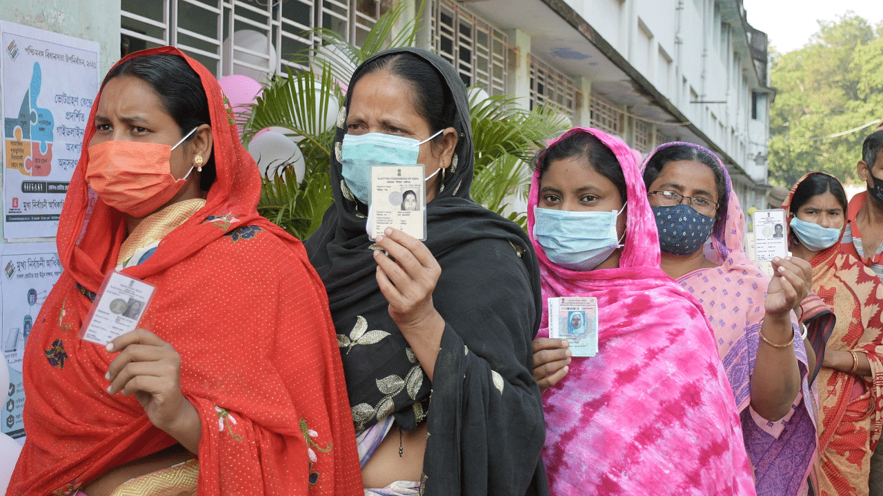 Female voters show their identity cards as they stand in a queue to cast their vote during Santipur by-polls, at a polling station in Nadia. Credit: PTI Photo