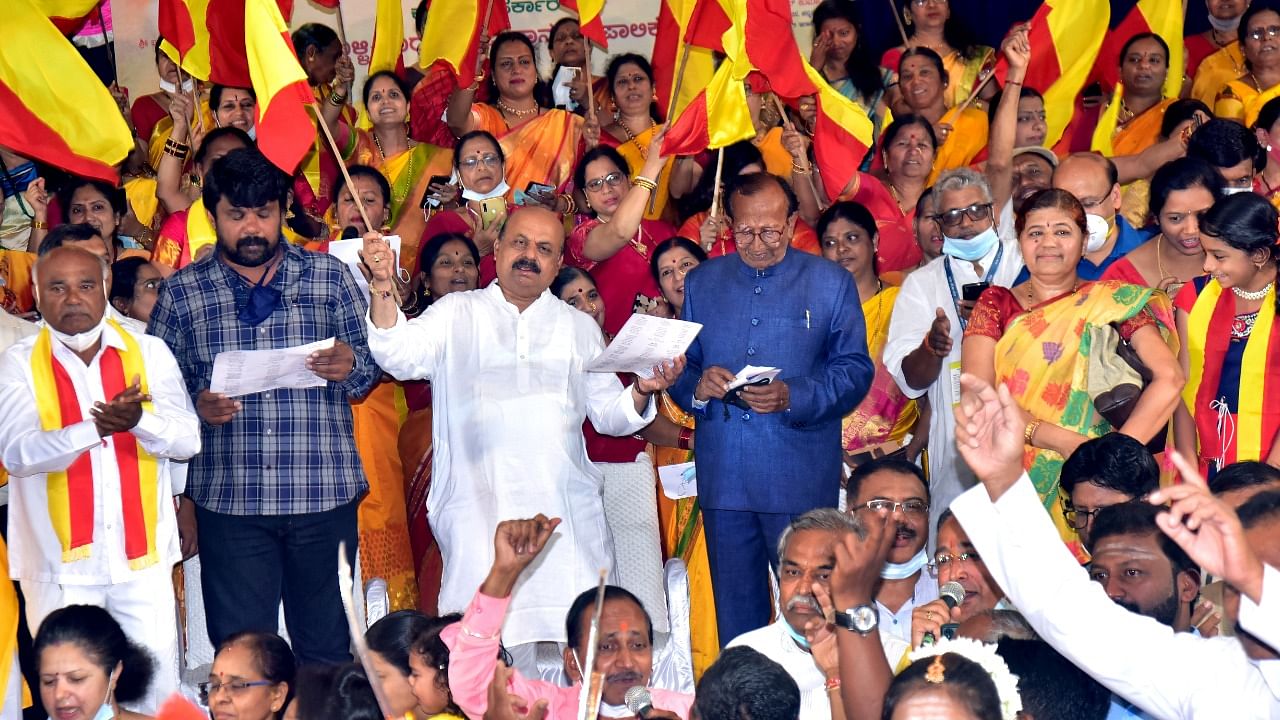 Chief Minister Basavaraj Bommai sings, along with MLA Raju Gouda, former MP I G Sanadi and others, at Kannada Geetagayana programme held in Hubballi on Thursday. Credit: DH File Photo