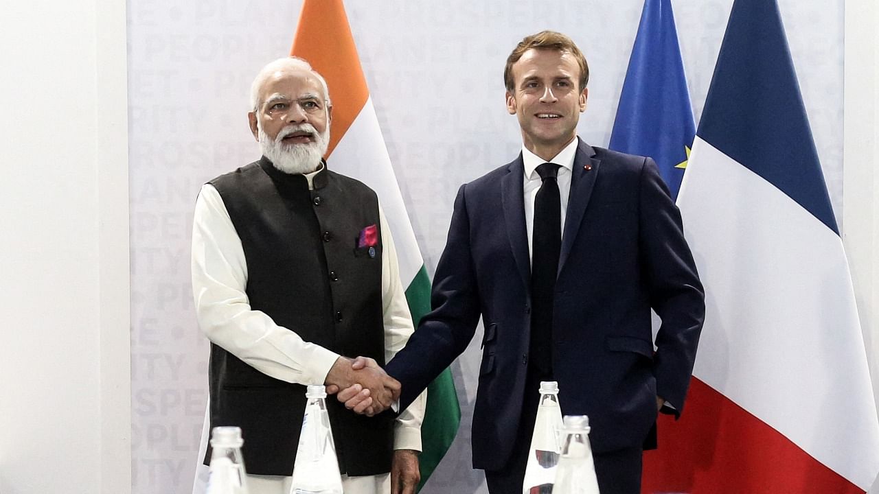 Indian Prime Minister Narendra Modi (L) shakes hands with French President Emmanuel Macron (R) during a bilateral meeting at the G20 leaders' summit in Rome. Credit: AFP Photo
