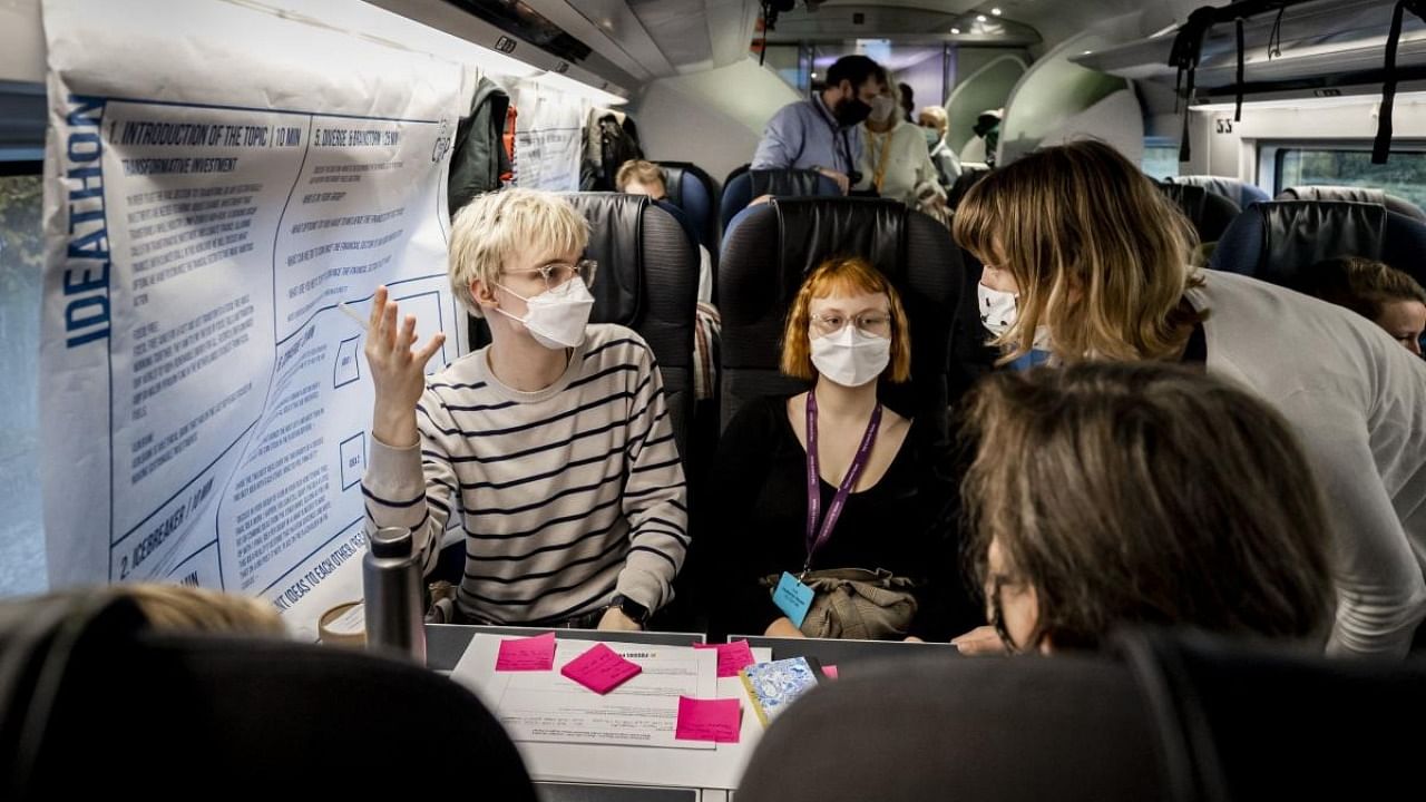 Passengers chat in a special Climate Summit train, which runs from Amsterdam Central, via Rotterdam and Brussels to London. Credit: AFP Photo