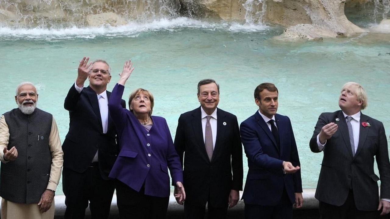 G20 leaders from left, India's Prime Minister Narendra Modi, Australia's Prime Minister Scott Morrison, German Chancellor Angela Merkel, Italy's Prime Minister Mario Draghi, French President Emmanuel Macron and British Prime Minister Boris Johnson perform the traditional coin toss in front of the Trevi Fountain during an event for the G20 summit in Rome. Credit: AP/PTI Photo