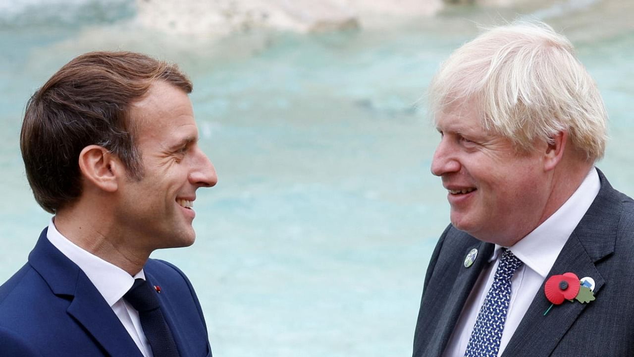 French President Emmanuel Macron and Britain's Prime Minister Boris Johnson talk in front of the Trevi Fountain during the G20 summit in Rome. Credit: Reuters photo