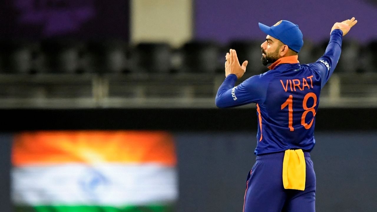 Virat Kohli adjusts the field during India's 8-wicket loss to New Zealand in the T20 World Cup. Credit: AFP Photo