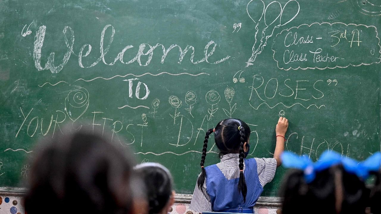 A girl draws on a board inside a classroom in New Delhi on November 1, 2021 as schools reopen after months due to the Covid-19 coronavirus pandemic. Credit: AFP Photo