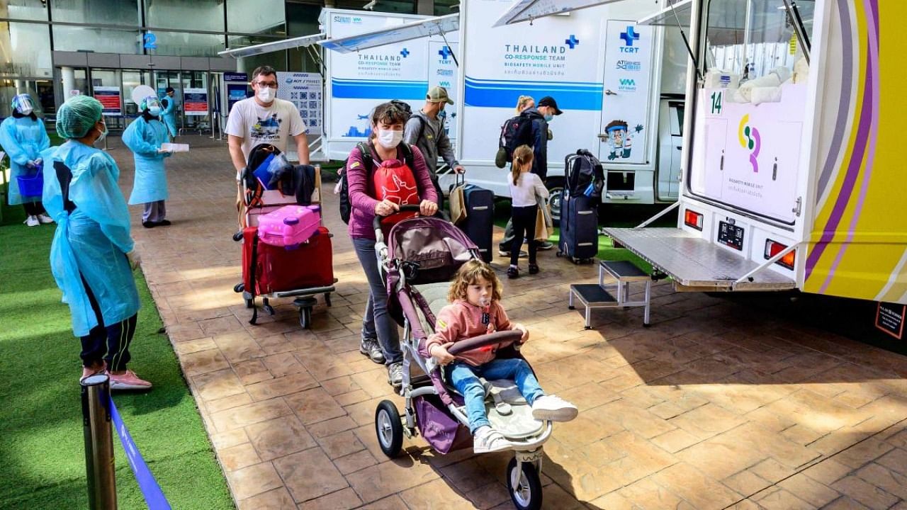 A family walks through the arrival area at Phuket International Airport as Thailand welcomes the first group of tourists fully vaccinated against the Covid-19 coronavirus without quarantine in Phuket. Credit: AFP Photo