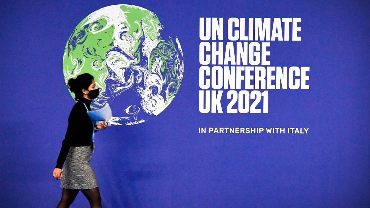 A participant walks past a COP26 UN Climate Change Conference' poster on the first day of the COP26 UN Climate Change Conference at the Scottish Event Campus (SEC) in Glasgow. Credit: AFP Photo
