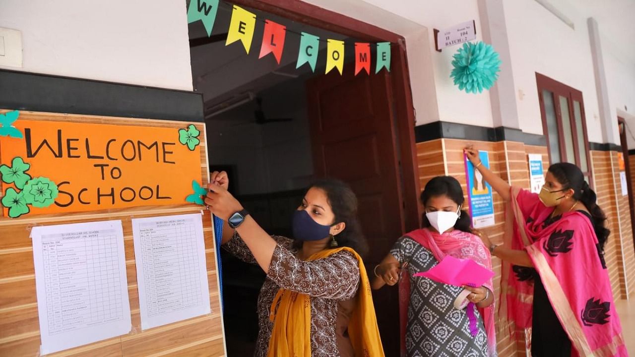 Teachers decorate a classroom at Silver Hills Higher Secondary school, ahead of the reopening of schools in the state, in Kozhikode. Credit: PTI Photo