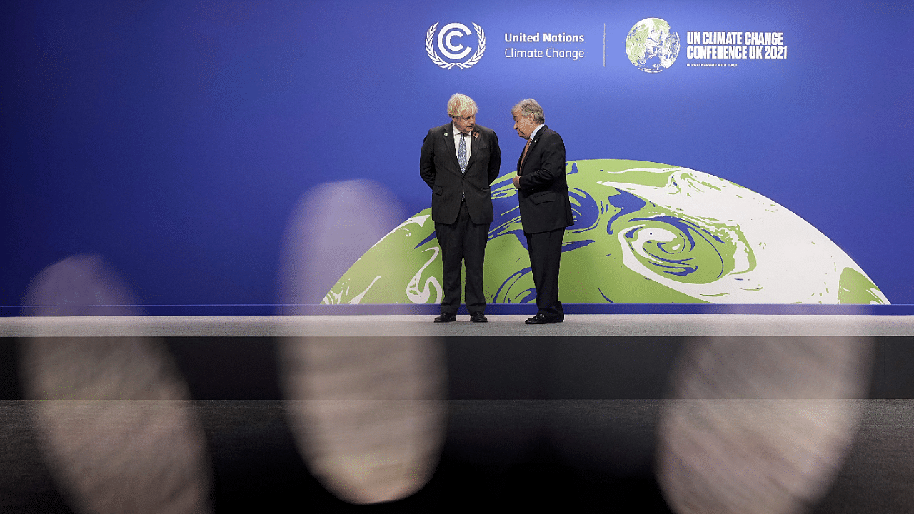 Britain's Prime Minister Boris Johnson (L) and United Nations (UN) Secretary General Antonio Guterres wait to greet leaders as they arrive to attend the COP26 UN Climate Change Conference in Glasgow. Credit: AFP Photo