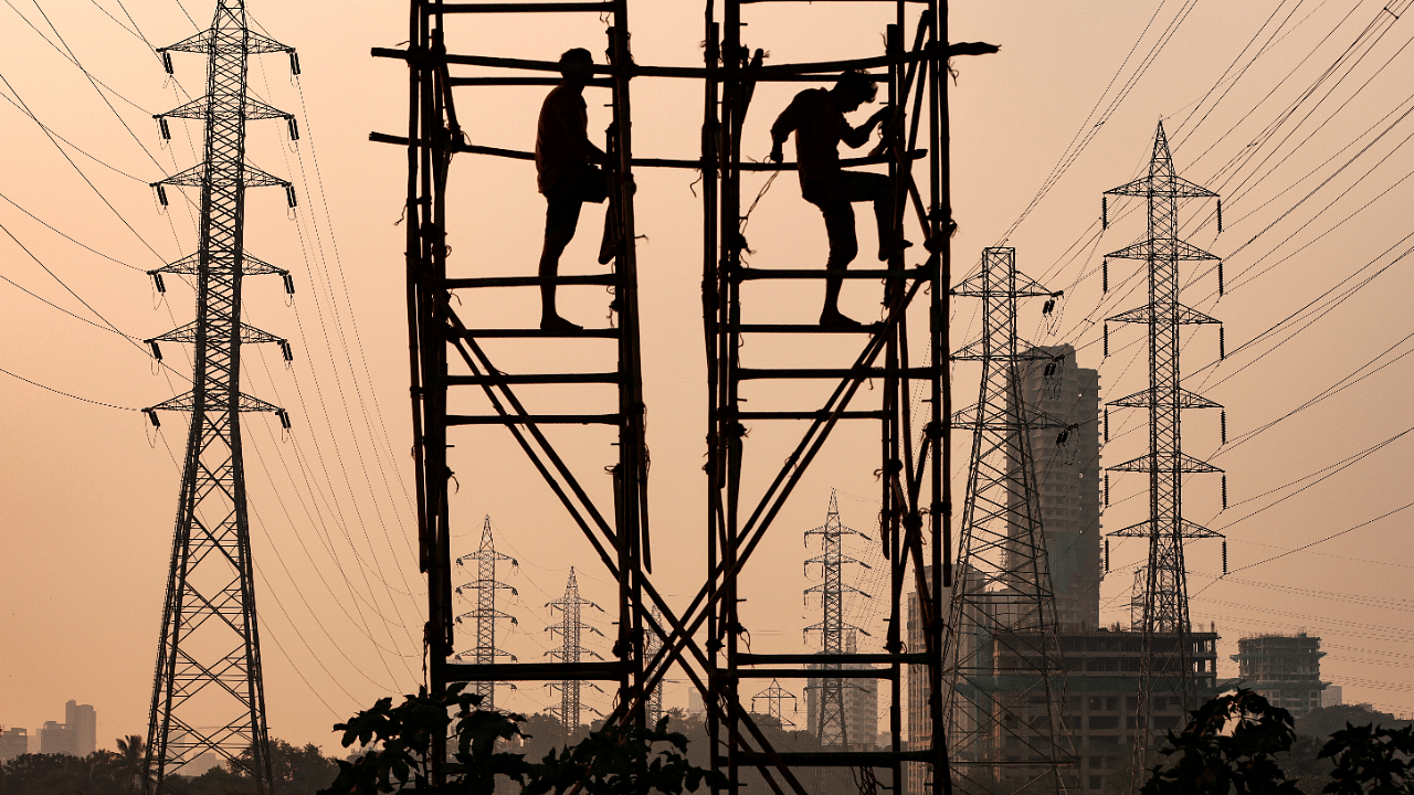 Labourers work next to electricity pylons in Mumbai. Credit: Reuters Photo