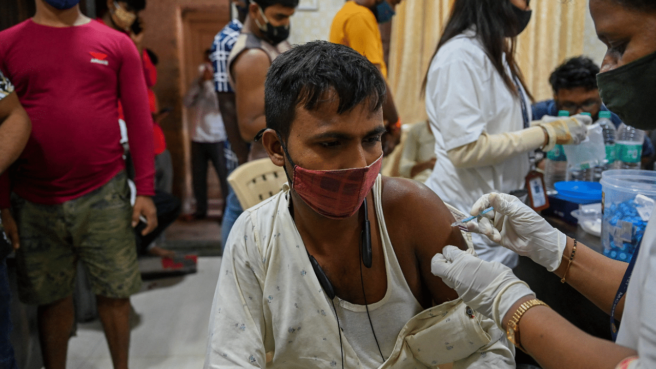 A worker gets inoculated with a dose of Covishield vaccine against the Covid-19. Credit: AFP Photo