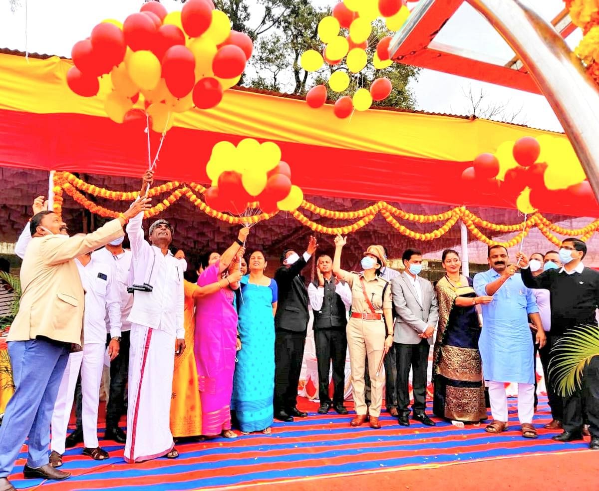 Minister Kota Srinivas Poojary and others release balloons with the colours of the Kannada flag, during the Karnataka Rajyotsava celebrations, at General Thimayya Stadium in Madikeri on Monday. DH Photo