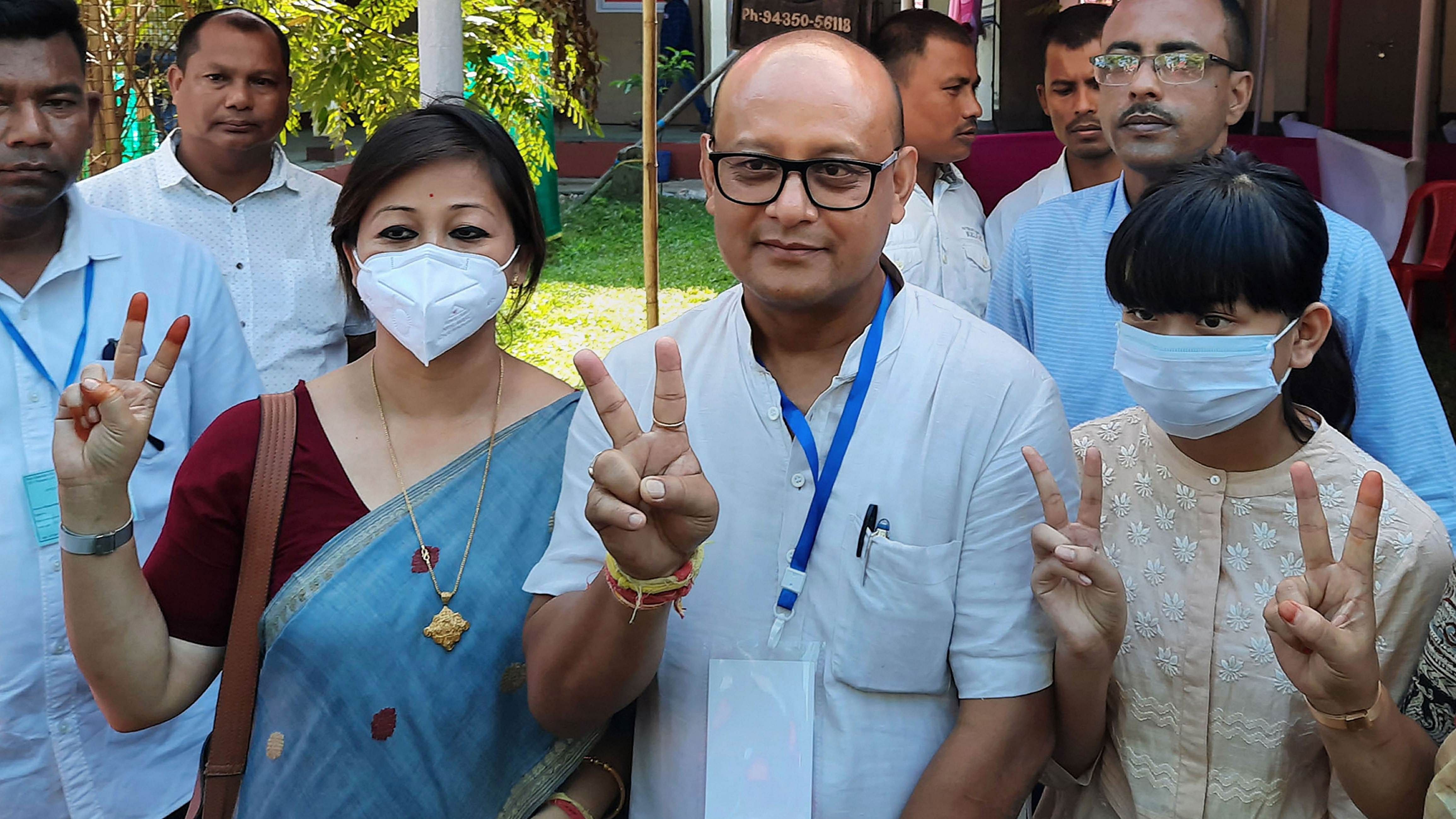  BJP candidate from Thowra constituency Sushanta Borgohain (C) with family members flash victory sign after winning in assembly by-elections, in Sivasagar district. Credit: PTI Photo