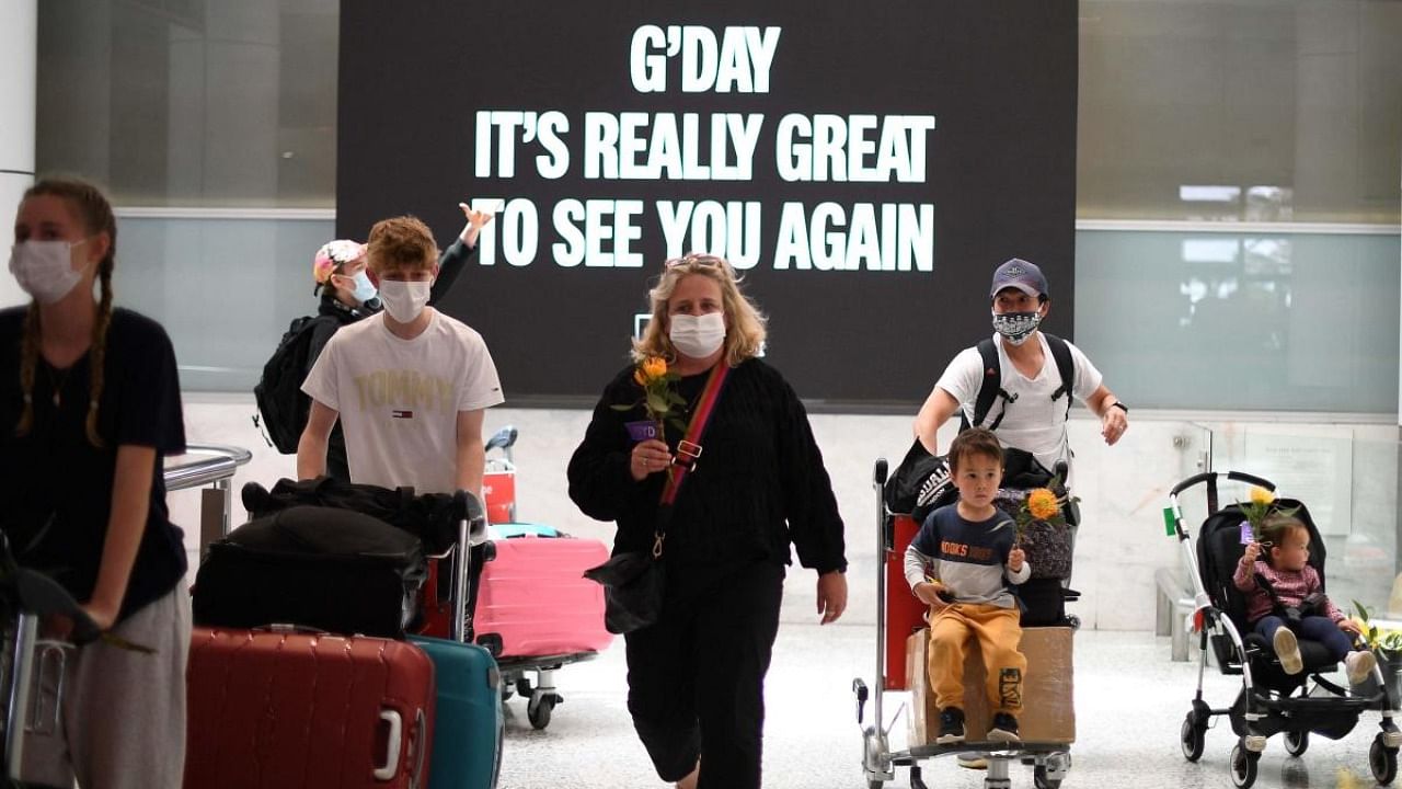 Families walk out of the arrivals hall at Sydney's International Airport on November 1, 2021, as Australia's international border reopened almost 600 days after a pandemic closure began. Credit: AFP Photo