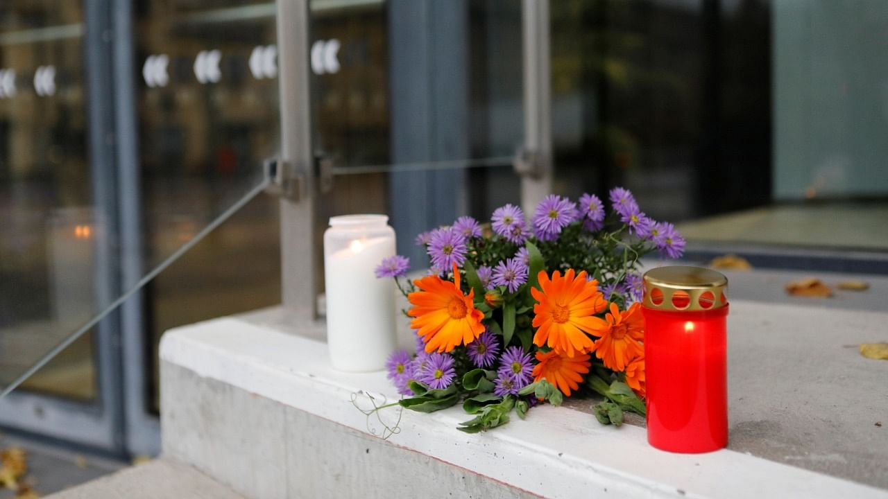 Flowers and candles are placed at the door of Uppsala Konsert and Kongress hall where two people were killed and another injured after a person fell from several metres, in Uppsala, near Stockholm, Sweden November 3, 2021. Credit: Reuters Photo