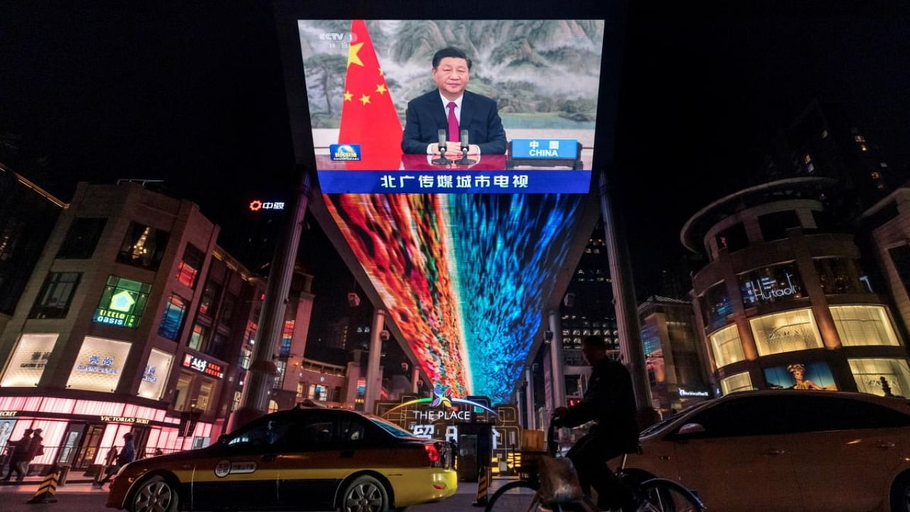 A screen displays a CCTV state media news broadcast showing Chinese President Xi Jinping addressing world leaders at the G20 meeting in Rome via video link at a shopping mall in Beijing, China. Credit: Reuters Photo